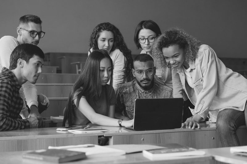 A group of students working together around a laptop