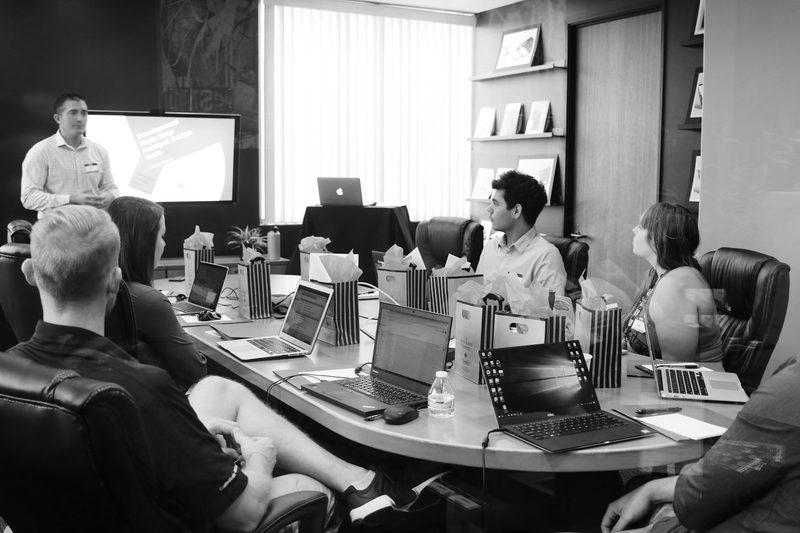 A consultant presenting to a seated group in a meeting room
